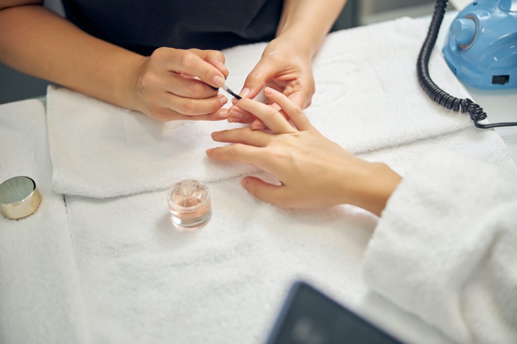 Nail artist doing manicure with gel for client